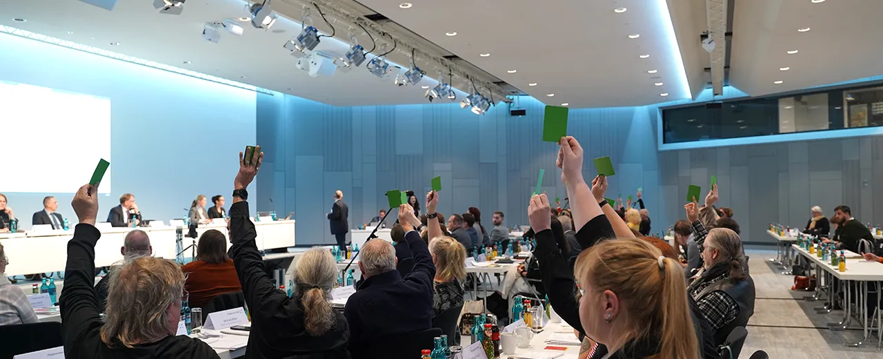 Abstimmung während einer Kammerversammlung wo einige Mitglieder grüne Karten hoch heben